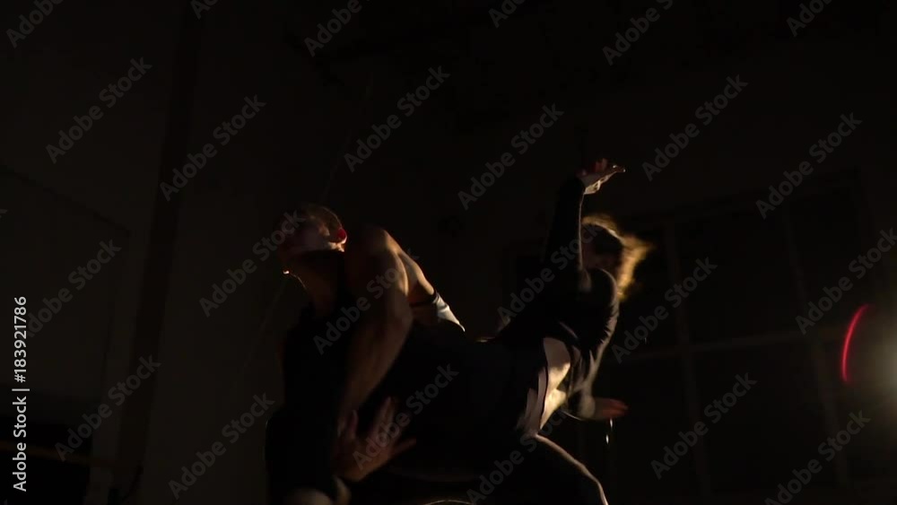 A bald man twists a woman in the air and puts himself on his knee A bald man twists a woman in the air and puts himself on his knee