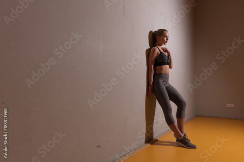 sportliche Frau posiert an der Wand © Christian Schwier