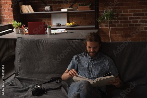 Man sitting on sofa and looking at photo album photo