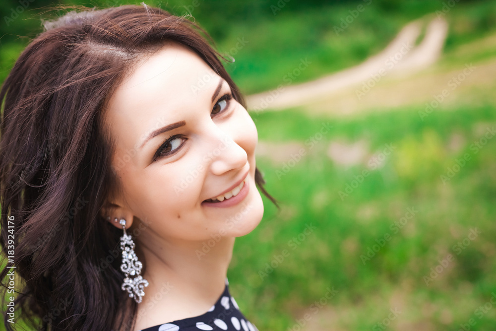 portrait of young pretty girl with long brunette hair in vintage black dress in white peas smiling in nature portrait of young pretty girl with long brunette hair in vintage black dress in white peas smiling in nature