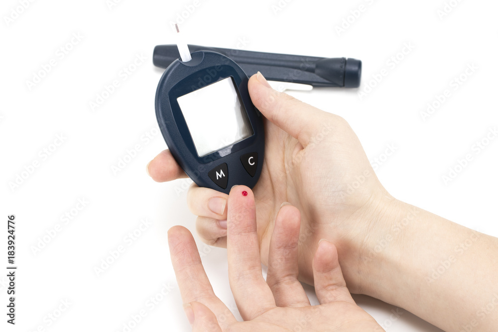 Close up of woman hands using lancet on finger to check blood sugar level by Glucose meter using as Medicine, diabetes, glycemia, health care and people concep Close up of woman hands using lancet on finger to check blood sugar level by Glucose meter using as Medicine, diabetes, glycemia, health care and people concep