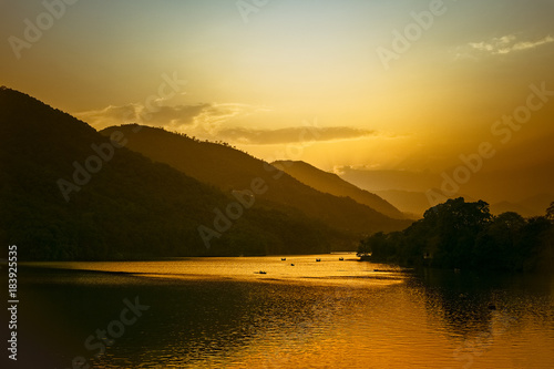 Obraz na płótnie magical orange watm sunset in lake with many boats. nepal