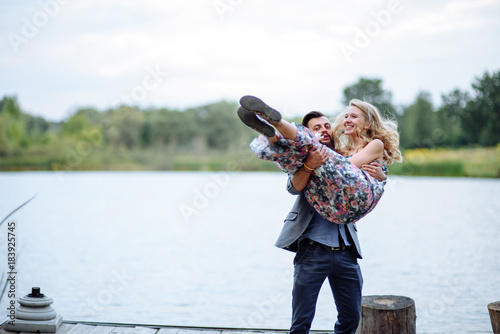 An offer of marriage. Love story. A bearded hipster guy carries a beloved girl in her arms and asks for hands and a heart.