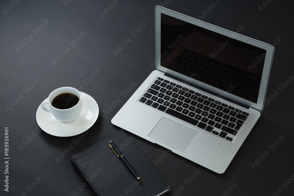 Black coffee, pen, organizer and laptop on black background Black coffee, pen, organizer and laptop on black background