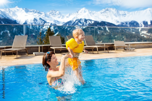 Family in outdoor swimming pool of alpine spa resort