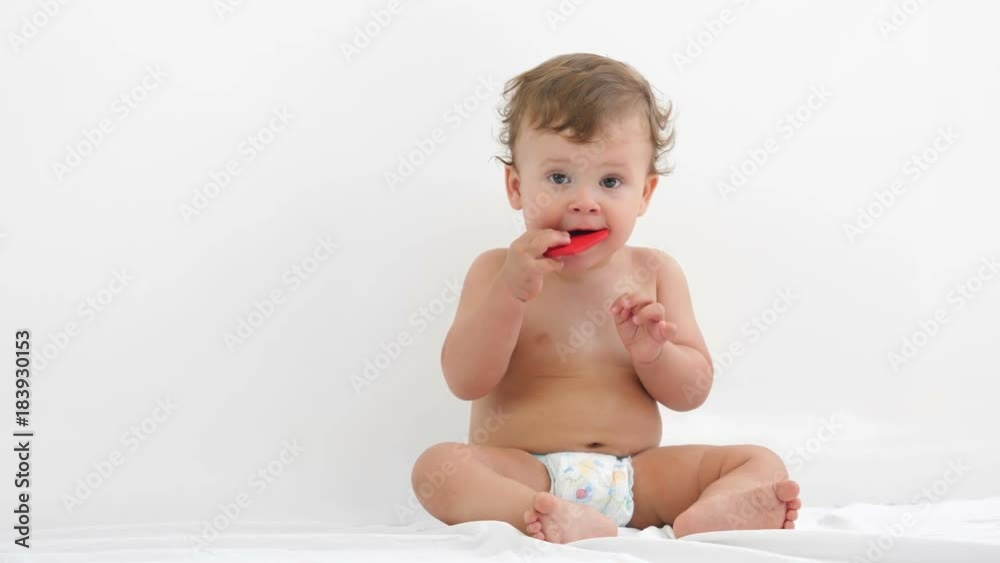Studio shot of an adorable little baby boy in white diapers smiling and looking up on white background.
Studio shot of an adorable little baby boy in white diapers smiling and looking up on white background.