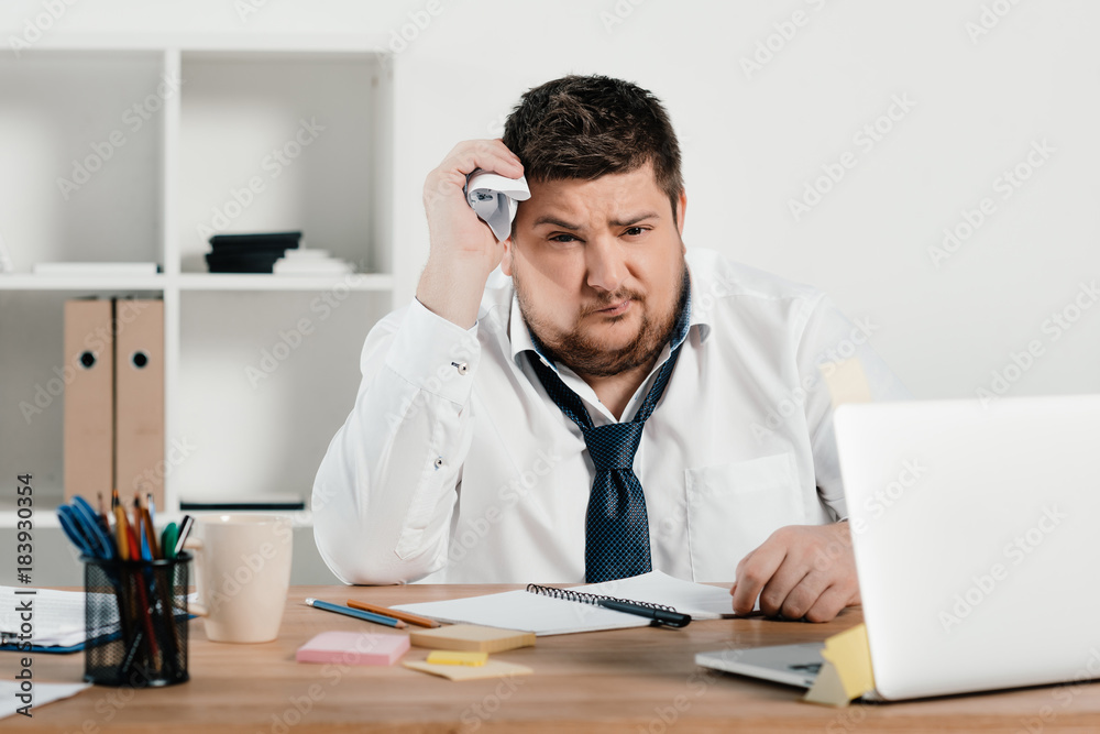 overweight businessman working with notepad and laptop in office overweight businessman working with notepad and laptop in office