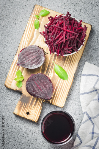 Sliced beetroot in a bowl and beetroot juice on stone background. Top view, copy space.