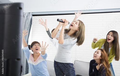 young woman holding microphone and singing at karaoke. photo