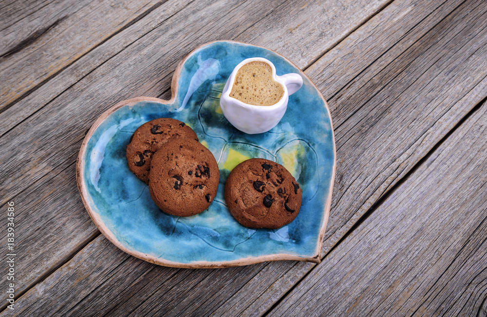 Plate in the shape of a heart and a cup with coffee in the shape of a heart. Plate in the shape of a heart and a cup with coffee in the shape of a heart.
