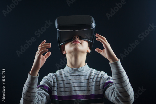 close-up boy 10 years old using a virtual reality helmet. Child getting experience in using VR 360 photo