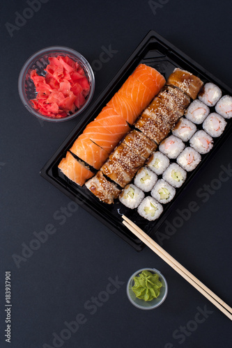 Popular Japanese food - Sushi rolls set with wasabi  ginger and chopsticks  top view.