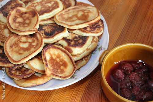 Pancakes and jam. Eating on a wooden table