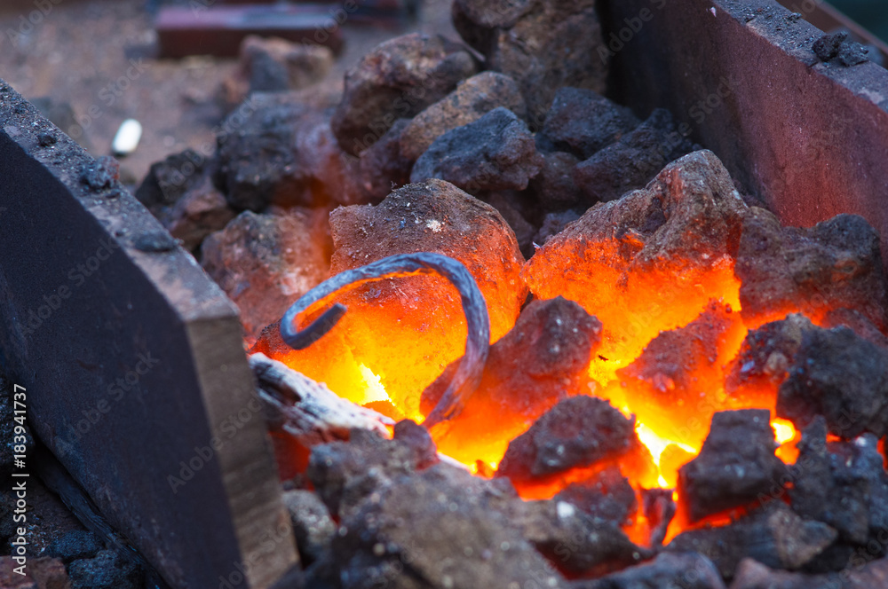 blacksmith furnace with burning coals, tools, and glowing hot metal workpieces blacksmith furnace with burning coals, tools, and glowing hot metal workpieces