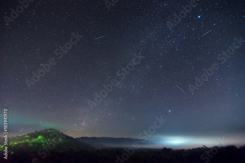 Milky way on hill with Leonid meteor shower.