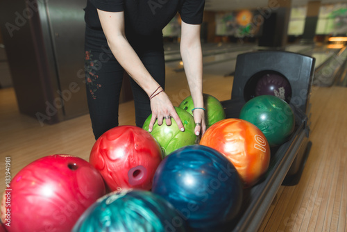 Women choose a bowling ball. Choosing colored balls for bowling.