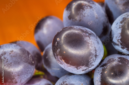 Berry blue wine grapes on a red saucer