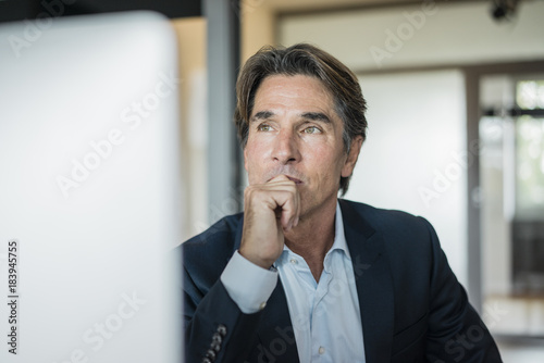 Portrait of businessman in office thinking photo