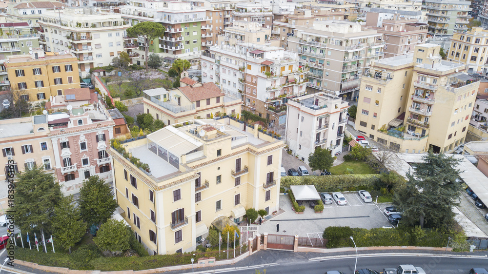 Vista aerea di una parte della citta di Roma. Tanti palazzi sono presenti tra le vie della città con qualche albero piantato nelle piazze e nei viali.