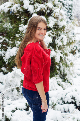 Beautiful young girl model in winter in a parked park. in a red sweater. © Oleksandr Masnyi