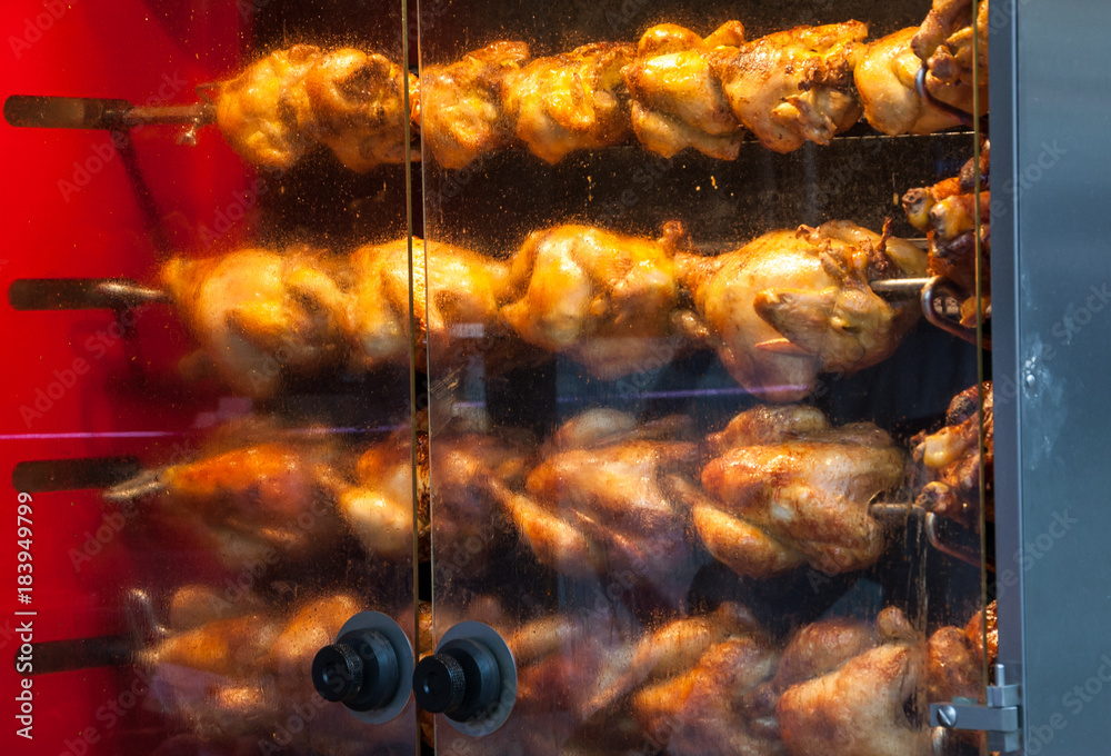 Rotisserie chicken near the entrance to the butcher shop in Paris
