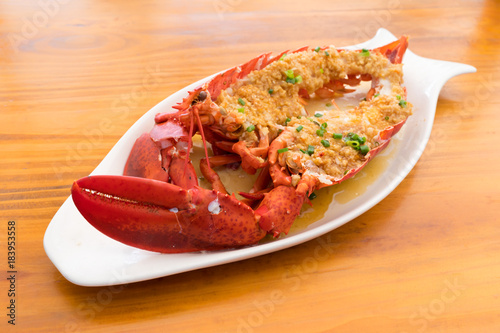Lobster baked with herbs against the background of a wooden table