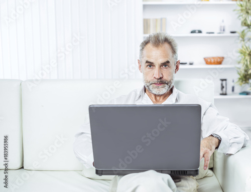 Wallpaper Mural successful businessman working on laptop sitting on sofa in modern office. Torontodigital.ca