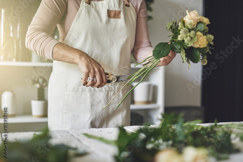 Florist making a bouquet while working in her flower ship photo