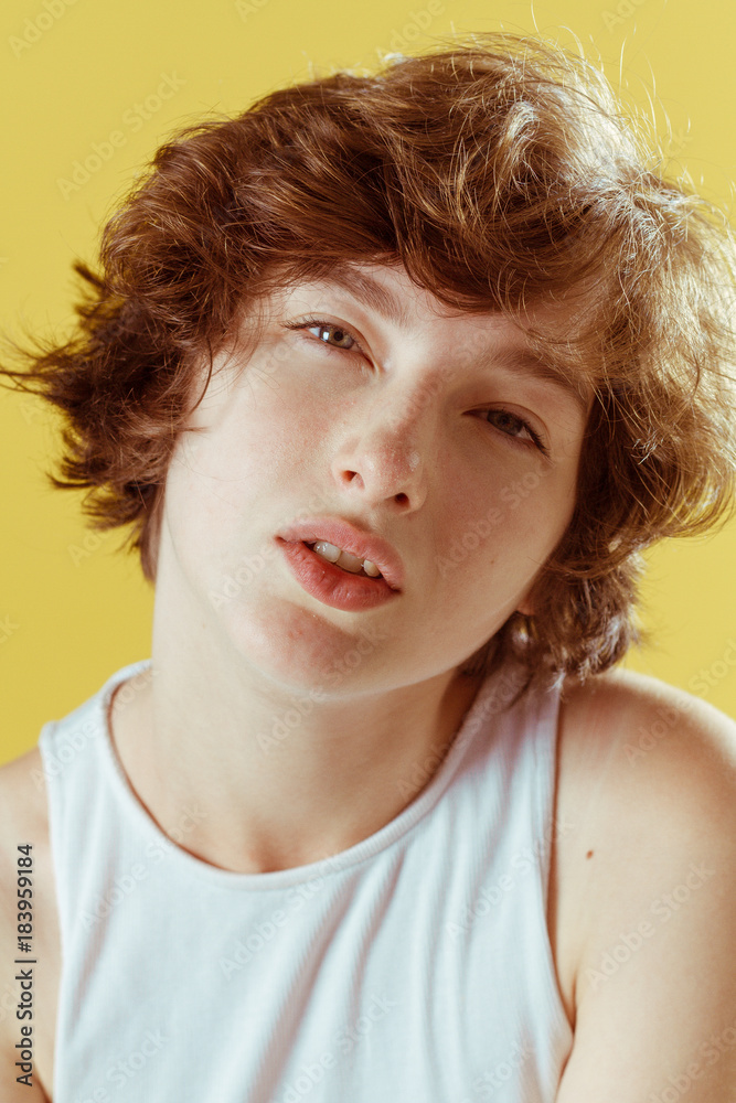 Beautiful and emotional girl on a yellow background without make-up and with natural skin Beautiful and emotional girl on a yellow background without make-up and with natural skin