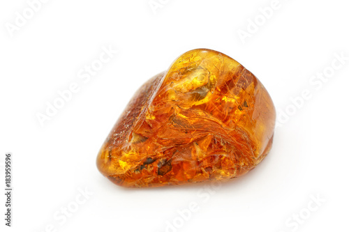Amber. Very beautiful piece of amber with waves and patterns inside on a white background. It looks like hohlomu. A natural stone. Fashionable decoration. A sunny stone. Vintage Wood Resin