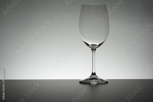 Crystal glass illuminated on mirror and black background