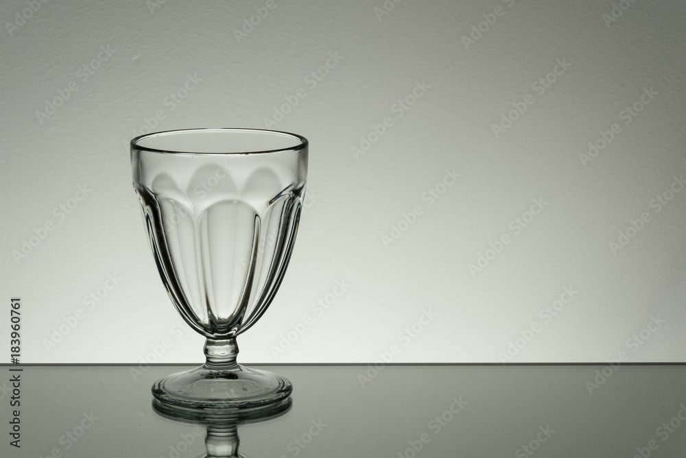 Crystal glass illuminated on mirror and black background Crystal glass illuminated on mirror and black background