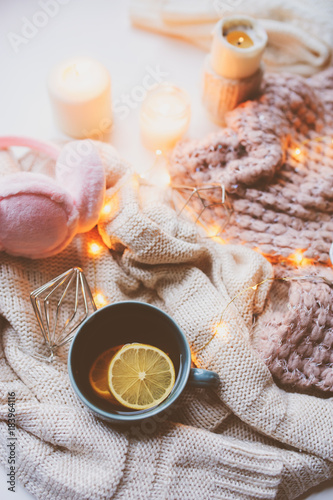 Cozy winter morning at home. Hot tea with lemon, knitted sweaters and modern interior details. Flat lay still life composition.