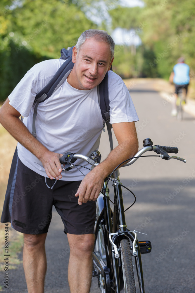 middle aged man cycling through countryside