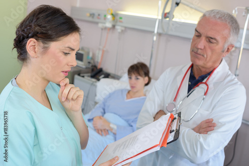 male doctor discussing some medical records with nurse