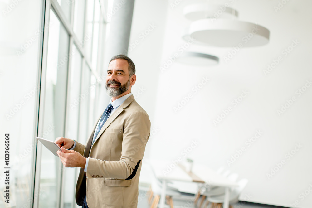 Middle aged  businessman with tablet in office