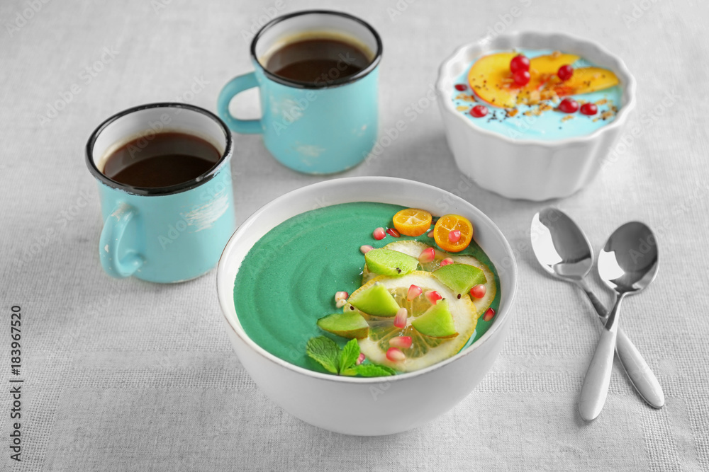 Bowl with green spirulina smoothie on table. Healthy vegan food concept Bowl with green spirulina smoothie on table. Healthy vegan food concept