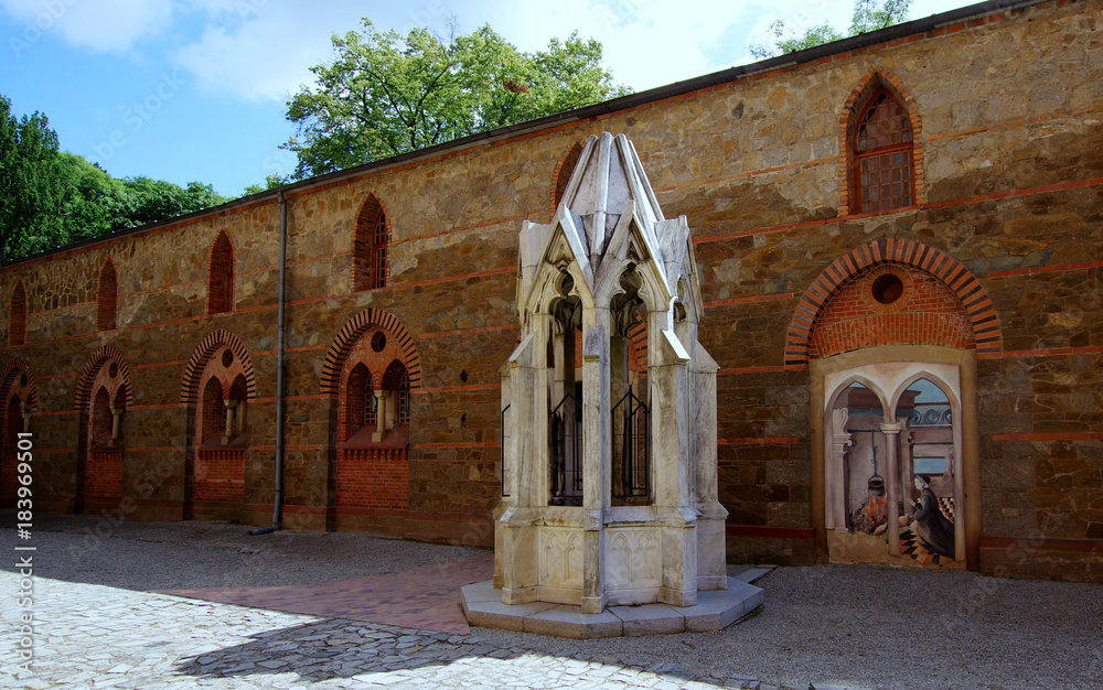 Studnia z rzeźbioną, ozdobną konstrukcją naziemną na pałacowym dziedzińcu w Kamieńcu Ząbkowickim