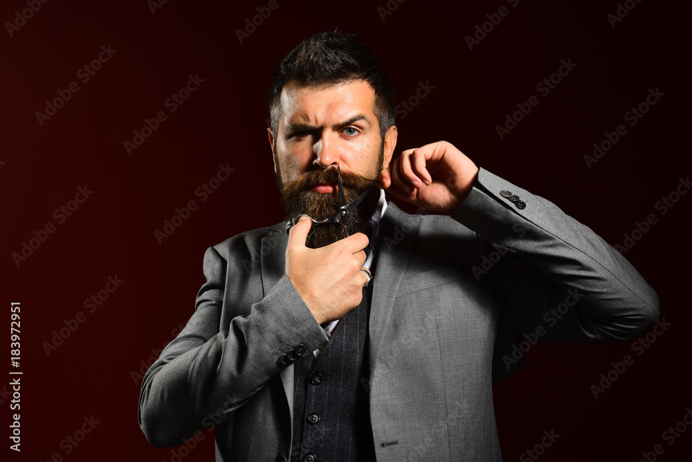 Obraz premium Businessman with strict face on dark red background.
