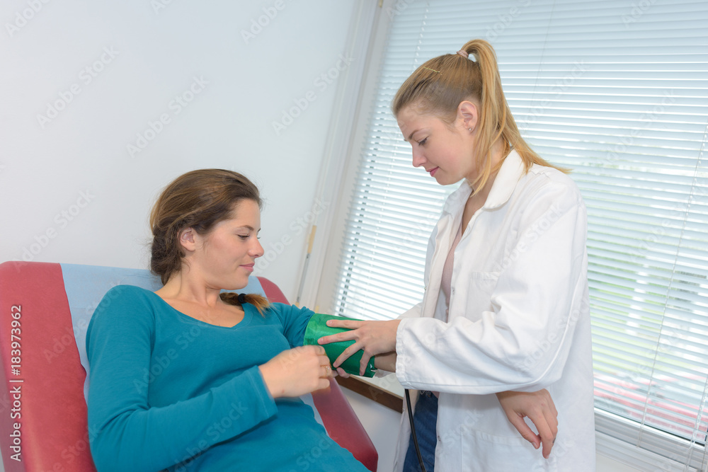 nurse measuring pressure of pregnant woman nurse measuring pressure of pregnant woman