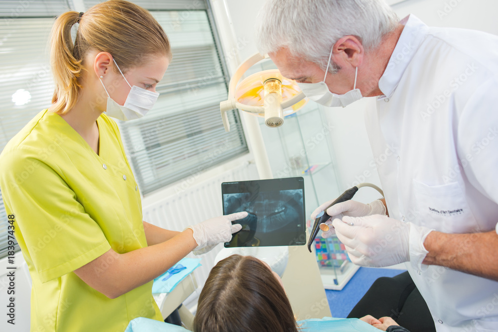 Busy dentist with a patient Busy dentist with a patient