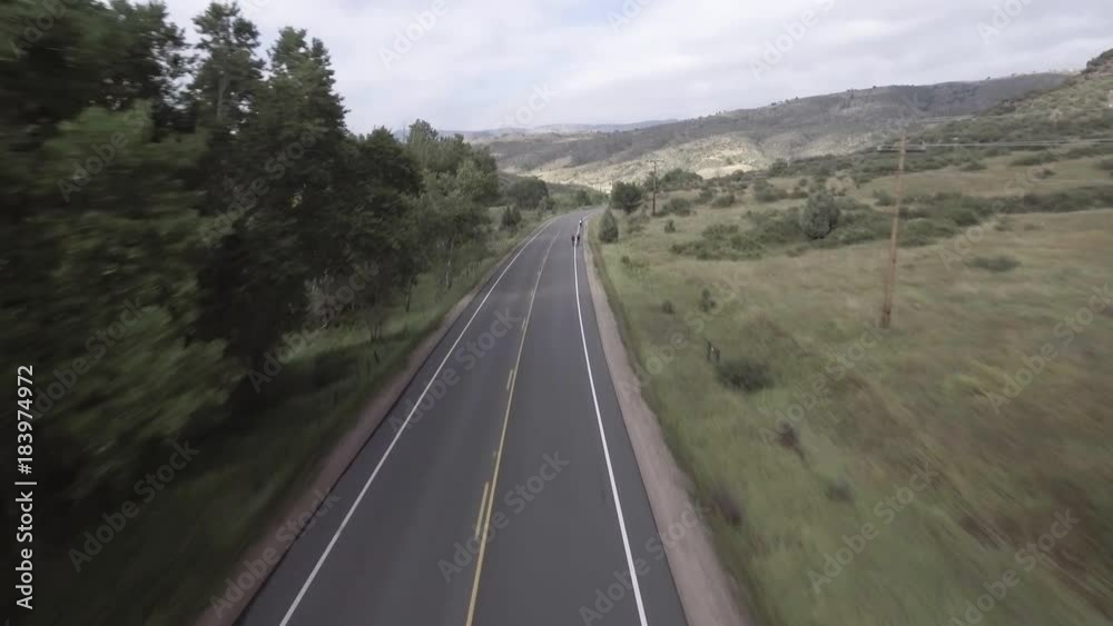 Tilt up, aerial of cyclists on highway Tilt up, aerial of cyclists on highway