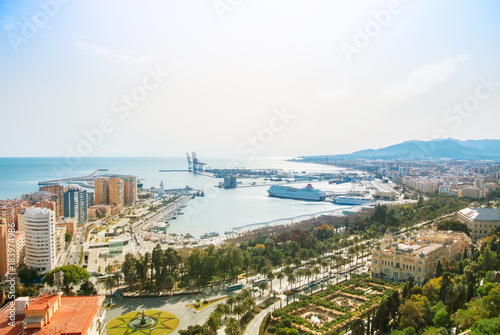 MALAGA, SPAIN - FEBRUARY 16, 2014: Panoramic view to the port of Malaga, big cruise ships, park and promenade from the Gibralfaro Castle, Andalusia, Spain, on sunny evening.