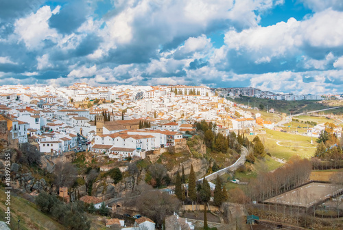 Aerial panoramic view of Ronda, tradational white houses with tile roofs on the hill and its surroundings, one of most famous white villages (pueblos blancos) in Malaga province, Andalusia, Spain.