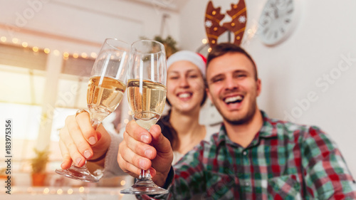Merry Christmas and Happy New Year! Couple drinking champagne at home for Christmas
