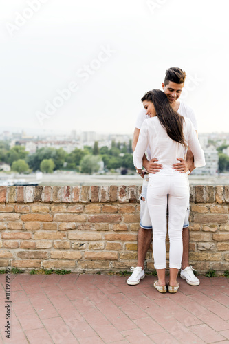 Young couple holding each other around waist