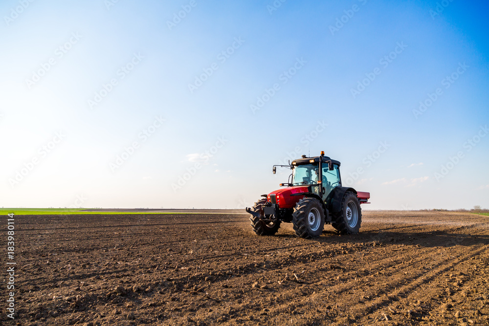 Farmer fertilizing arable land with nitrogen, phosphorus, potassium fertilizer Farmer fertilizing arable land with nitrogen, phosphorus, potassium fertilizer