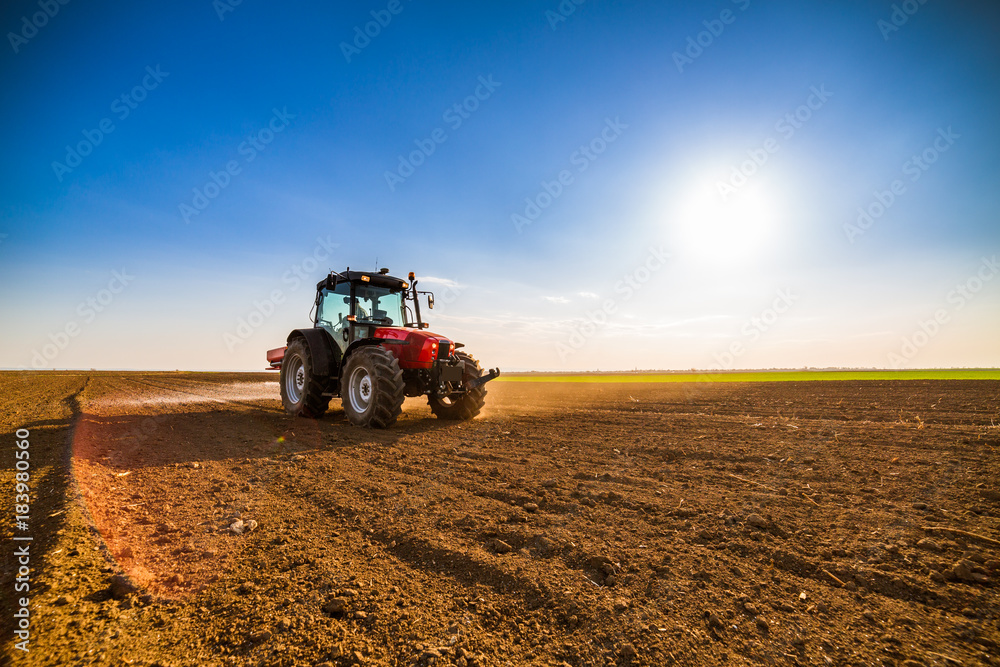 Obraz premium Farmer fertilizing arable land with nitrogen, phosphorus, potassium fertilizer