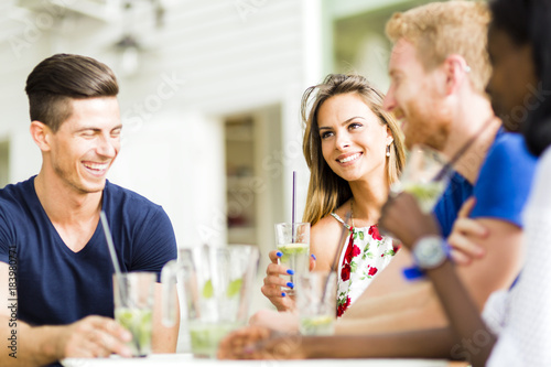 Young and happy friends sitting talking at a table