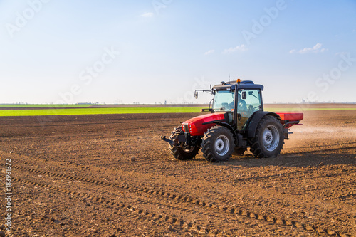 Farmer fertilizing arable land with nitrogen  phosphorus  potassium fertilizer